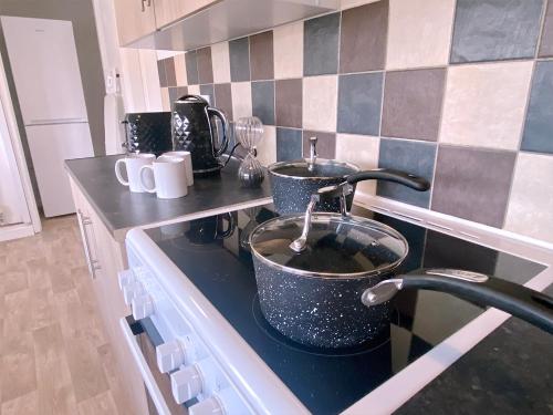 a kitchen with two pots and pans on a stove at Group stays Wolverhampton M6 J10 in Bilston