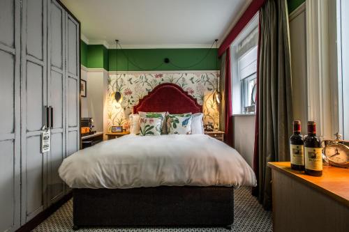 a bedroom with a large bed with a red headboard at Orange Tree in Richmond upon Thames