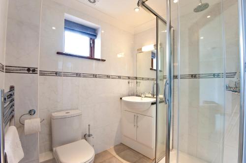 a bathroom with a toilet and a sink and a shower at Green Acres Cottages in Par