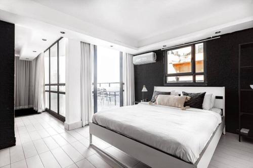 1 dormitorio con 1 cama grande y balcón en 3Bedroom Suite with Balcony Shenkin Hotel, en Tel Aviv
