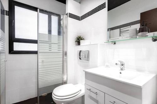 Baño blanco con aseo y lavamanos en 3Bedroom Suite with Balcony Shenkin Hotel, en Tel Aviv