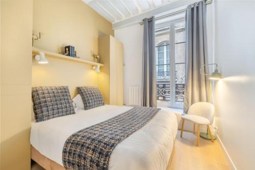 a bedroom with a bed and a window and a chair at La Rue in Paris