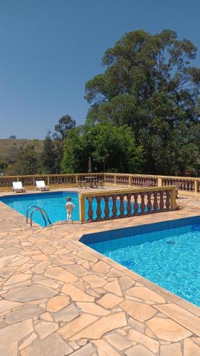 uma piscina com um banco no meio em Pousada & Pesca Esportiva Fazolin em Socorro