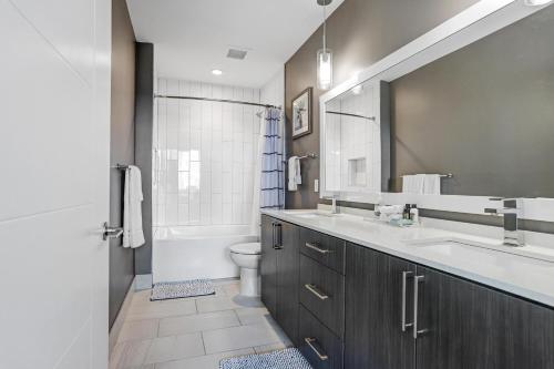 a bathroom with a sink and a toilet and a shower at Stunning 2-Bed Condo with Panoramic DT Tampa Views in Tampa