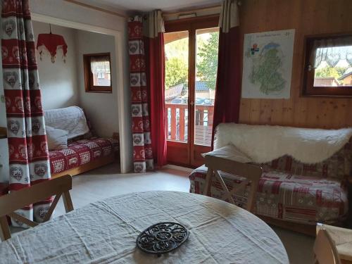 a room with a bed and a table and a window at Joli Appt 2 Centre Village Valloire in Valloire