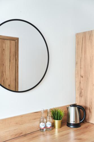 a round mirror on a counter with bottles on it at Na Fursie Apartments & Rooms in Nowy Targ