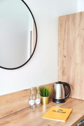 a mirror on top of a wooden counter with bottles of wine at Na Fursie Apartments & Rooms in Nowy Targ