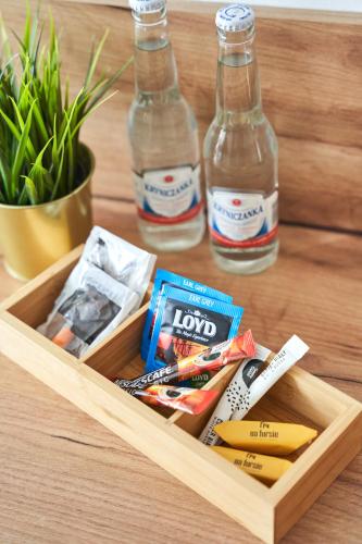 a wooden tray with snacks and two bottles of soda at Na Fursie Apartments & Rooms in Nowy Targ