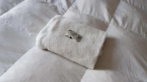 a white towel sitting on top of a white bed at Hotel Urbano Ventia in Comodoro Rivadavia