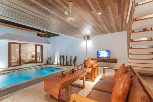 ein Wohnzimmer mit einem Pool und einem Sofa in der Unterkunft 3 Bedroom Private Villa Ubud in Ubud
