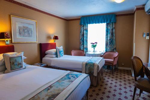 a hotel room with two beds and a window at London Lodge Hotel in London