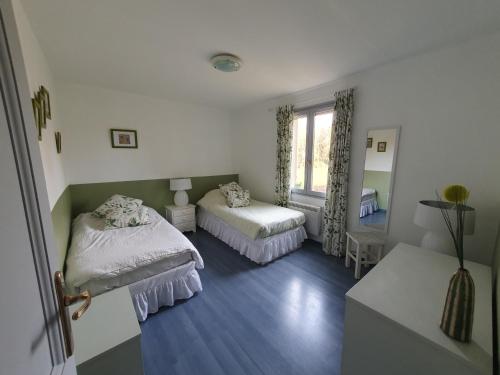a bedroom with two beds and a window at Le Temps d'une Pause in Andert-et-Condon