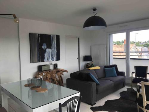 un salon avec un canapé et une table dans l'établissement Magnifique appartement avec sa grande terrasse, à Touques