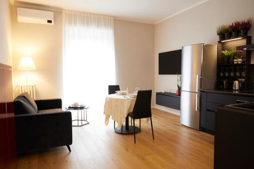 een keuken en een woonkamer met een tafel en een koelkast bij La casa di Albert - luxury living in Milaan