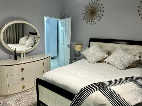 una camera da letto con un letto con specchio e un comò di Grace @ Rayton a Bloemfontein