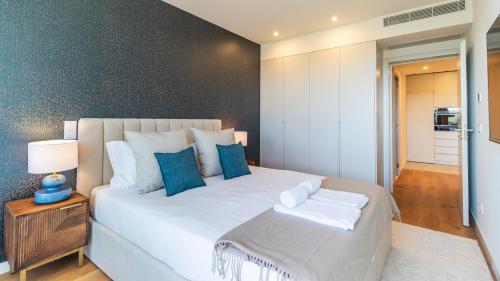 a bedroom with a large white bed with blue pillows at Casa do Sol by LovelyStay in Vila Nova de Gaia