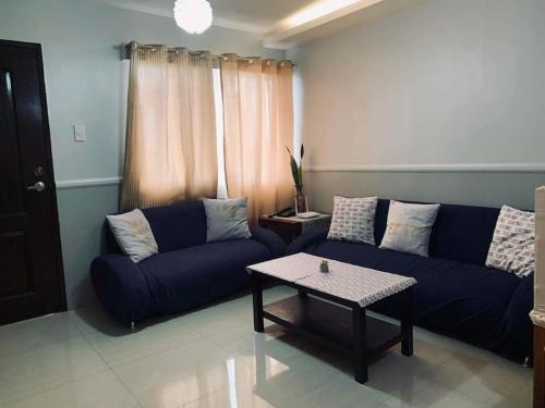a living room with a blue couch and a table at Appartement: 2 BR at One Oasis in Davao City