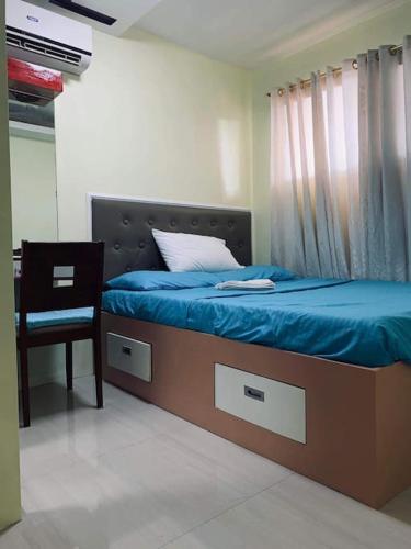 a bedroom with a bed with a chair and a window at Appartement: 2 BR at One Oasis in Davao City