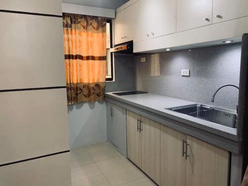 a kitchen with white cabinets and a sink at Appartement: 2 BR at One Oasis in Davao City