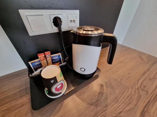 une cafetière assise sur un comptoir avec une cafetière dans l'établissement Center Hotel Essen, à Essen