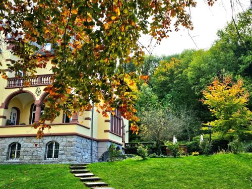 une grande maison avec une cour herbeuse devant elle dans l'établissement Hotel Erbprinzenpalais, à Wernigerode