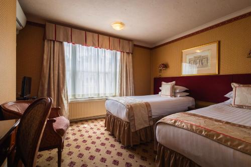 a hotel room with two beds and a window at London Lodge Hotel in London