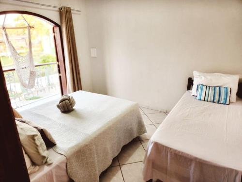 a room with two beds and a window at PousaDinháChica Hospedagem perto de Tiradentes Minas Gerais in São João del Rei