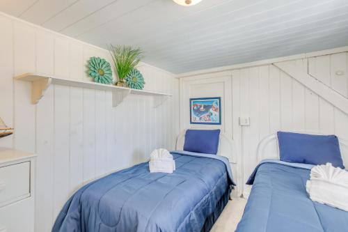two blue beds in a room with white walls at Coastal Cottage with Ocean View Walk to Pier in Myrtle Beach