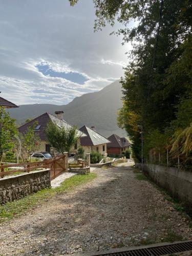 a dirt road with houses and mountains in the background at JOEN Village in Librazhd