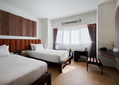 a hotel room with two beds and a desk at Panmanee Hotel in Phi Phi Islands