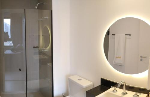 uma casa de banho com um chuveiro, um lavatório e um espelho. em VN Turiassu II em São Paulo