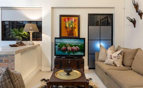 a living room with a tv and a couch at Seaforth Country House in Ballito