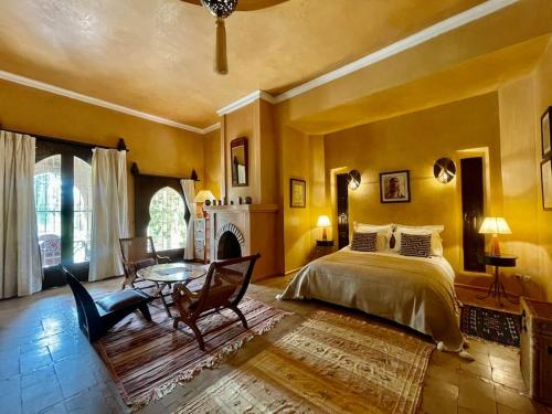 een slaapkamer met een bed, een tafel en een open haard bij Dar Zeitoun in Marrakesh