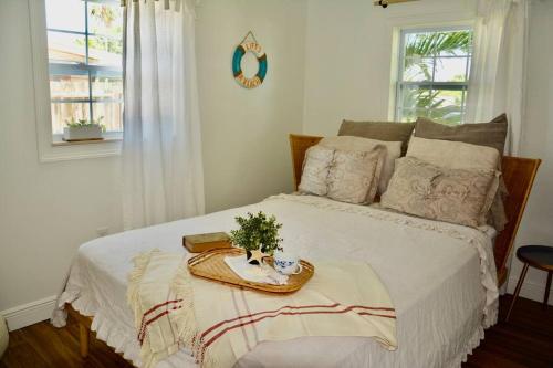 Un dormitorio con una cama blanca y una bandeja. en Tropical Retreat Near Beaches, Cruise Terminals en Merritt Island