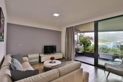 a living room with a couch and a television at Royal Gardens Paradise in Budva