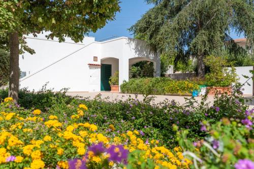 a garden with flowers in front of a white building at Luoghi di Puglia in Ostuni