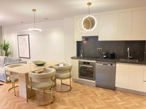 een keuken met een houten tafel en stoelen en een keuken met witte kasten bij Luxury Nişantaşı Apartment in Istanbul