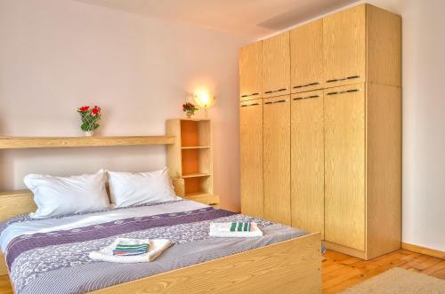 a bedroom with a bed and a large wooden cabinet at Guest House JoJi in Sapareva Banya
