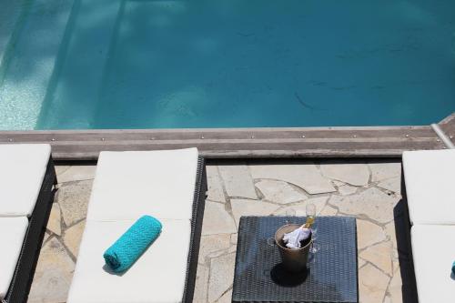 アンティーブにあるCôte d'Azur Villa - Juan-les-Pins - 900m beachのプールサイドのテーブルでドリンクを楽しめます。