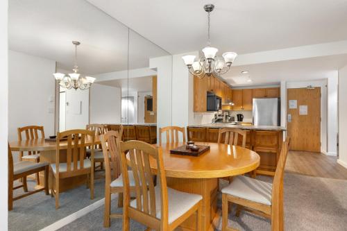 a kitchen and dining room with a wooden table and chairs at The Woodrun Lodge by Whiski Jack in Whistler