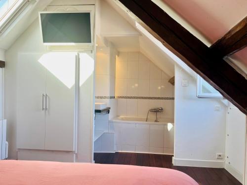 1 dormitorio en el ático con 1 cama y baño en Le Perchoir, appartement duplex au cœur d'Honfleur, en Honfleur