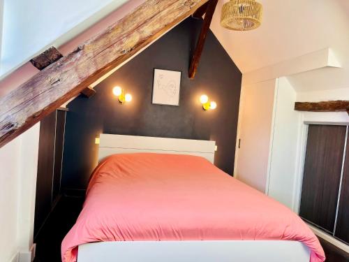 1 dormitorio con cama roja en el ático en Le Perchoir, appartement duplex au cœur d'Honfleur, en Honfleur