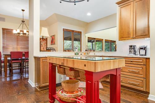een keuken met een groot eiland met rode benen bij Lake Austin Lakeside Retreat in Austin