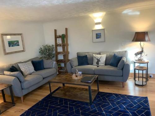 a living room with two couches and a coffee table at Ivy Cottage, Aberfeldy - Highland Perthshire in Aberfeldy