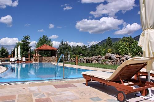a lounge chair next to a swimming pool at Vitina House in Vytina