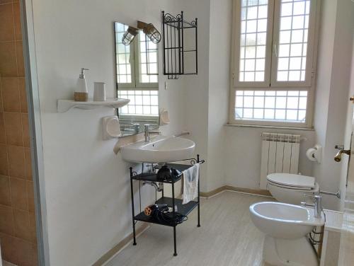 La salle de bains est pourvue d'un lavabo et de toilettes. dans l'établissement Santa Marinella Appartamento centralissimo a 2 passi dal mare, à Santa Marinella