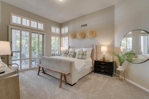 a bedroom with a bed and a mirror and windows at Luxe Scottsdale Retreat Pool, Hot Tub and More! in Phoenix