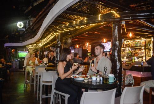 Un hombre y una mujer sentados en una mesa en un restaurante. en Siesta Fiesta Hotel Adults Only - 5th Avenue, en Playa del Carmen