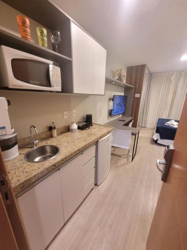 a kitchen with a sink and a microwave at Flat Saint Moritz Express By Rei dos Flats in Brasilia