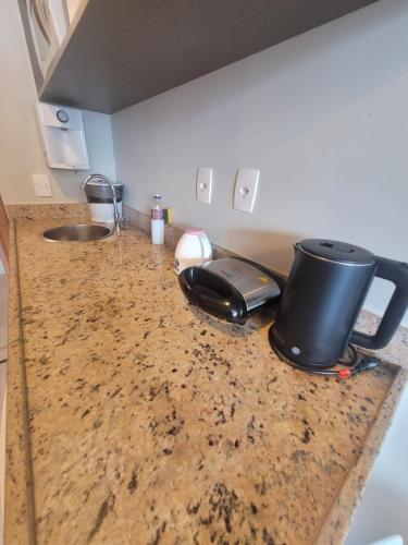 a kitchen counter with a sink and a phone on it at Flat Saint Moritz Express By Rei dos Flats in Brasilia